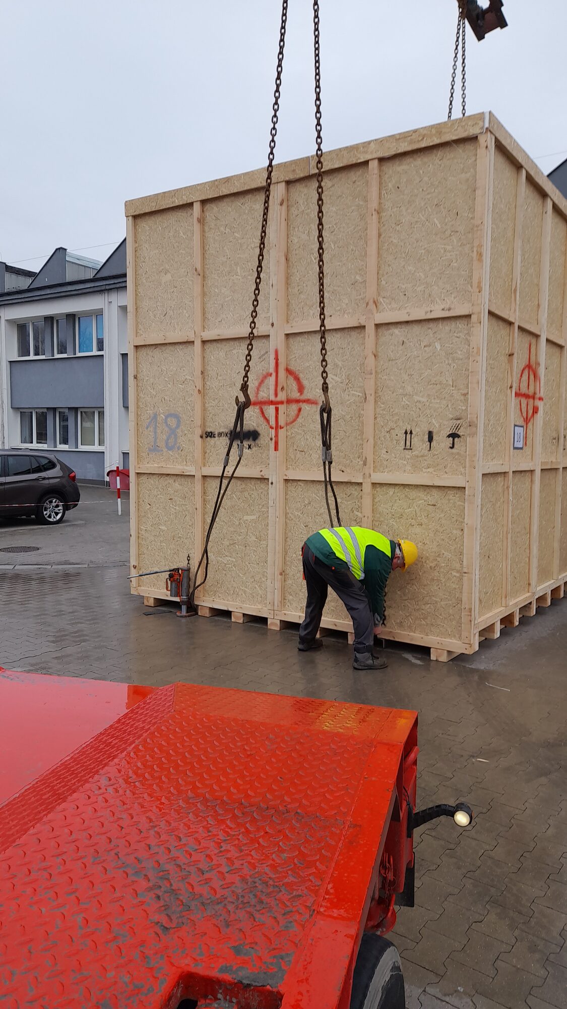 Podnoszenie skrzyni transportowej z maszyną za pomocą dźwigu